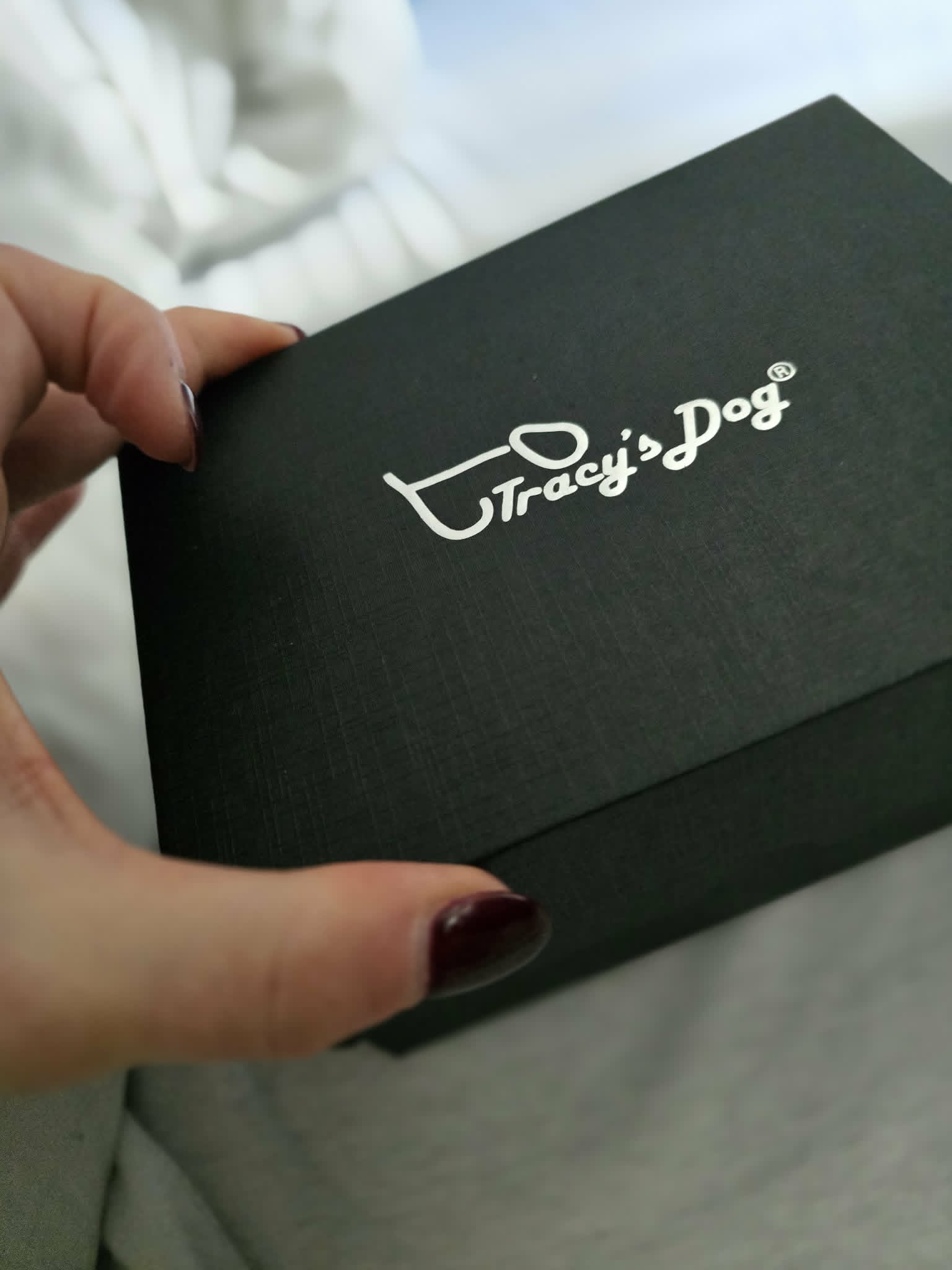 The Tracy's Dog inner presentation box — slim matte black with silver logo